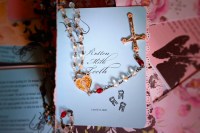 zine titled rotten milk teeth with rosary atop pile of other zines with varied covers